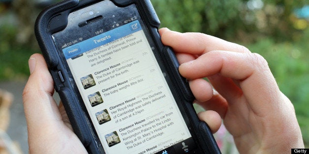 BRISTOL, ENGLAND - JULY 23: In this photo illustration a man looks at Twitter on a iPhone of tweets from Clarence House on July 23, 2013 in Bristol, England. The Duchess of Cambridge yesterday gave birth to a boy at 16.24 BST and weighing 8lb 6oz, with Prince William at her side. The baby, as yet unnamed, is third in line to the throne and becomes the Prince of Cambridge. (Photo by Matt Cardy/Getty Images)