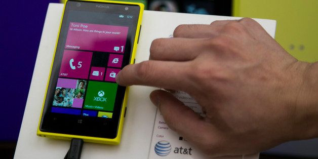 A sales associate performs a product demonstration of the Nokia Oyj Lumia 1020 mobile device at a Microsoft Corp. store in Boston, Massachusetts, U.S., on Tuesday, Sept. 3, 2013. Microsoft Corp. agreed to buy Nokia Oyj's handset unit and license its patents for 5.44 billion euros ($7.2 billion), seeking to revive two smartphone businesses that have struggled for a half-decade to gain share against Apple Inc. and Google Inc. photographer: Kelvin Ma/Bloomberg via Getty Images