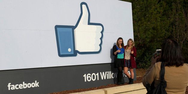Tourists take photos of the Facebook Inc. 'like' logo displayed on a sign at the entrance to company headquarters in Menlo Park, California, U.S., on Wednesday, Feb. 1, 2012. Facebook, the social-networking website that began about eight years ago in a Harvard University dorm and now boasts more than 800 million users, filed to raise $5 billion in an initial public offering. Photographer: David Paul Morris/Bloomberg via Getty Images 