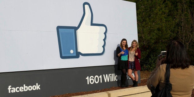 Tourists take photos of the Facebook Inc. 'like' logo displayed on a sign at the entrance to company headquarters in Menlo Park, California, U.S., on Wednesday, Feb. 1, 2012. Facebook, the social-networking website that began about eight years ago in a Harvard University dorm and now boasts more than 800 million users, filed to raise $5 billion in an initial public offering. Photographer: David Paul Morris/Bloomberg via Getty Images