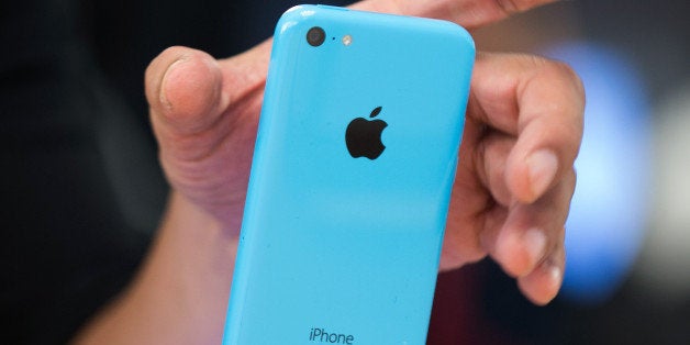 A customer views an Apple Inc. iPhone 5c displayed during the devices launch at the company's store in New York, U.S., on Friday, Sept. 20, 2013. Apple Inc. attracted long lines of shoppers at its retail stores today for the global debut of its latest iPhones, in the company's biggest move this year to stoke new growth. Photographer: Craig Warga/Bloomberg via Getty Images