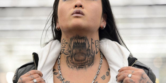 FRANKFURT AM MAIN, GERMANY - MARCH 22: Marlin (35) shows her Pitbull-Tattoo on her neck during the International Tattoo Convention on March 22, 2013 in Frankfurt am Main, Germany. The Frankfurt tattoo convention is considered the world's biggest fair for the art of tattooing. More than 700 artists from all over the world will make more than 3,000 tattoos at the three-day show. The Hessian state laboratory has found carcinogens in some tattoo inks produced in China, causing warnings to be issued Europe-wide. (Photo by Thomas Lohnes/Getty Images)