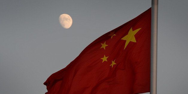 The Chinese flag is seen in front of a view of the moon at Tiananmen Square in Beijing on December 13, 2013. China's first lunar rover which entered the moon's orbit last week is expected to makes it's planned landing on the moon's surface on December 14. The rover known as Yutu, or Jade Rabbit will explore its surface and search for natural resources. AFP PHOTO/Mark RALSTON (Photo credit should read MARK RALSTON/AFP/Getty Images)