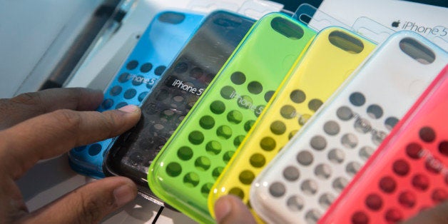 A store employee arranges Apple Inc. iPhone 5c cases for sale at a Reliance Digital store, a subsidiary of Reliance Industries Ltd., in New Delhi, India, on Saturday, Nov. 2, 2013. Reliance Communications Ltd. is the first Indian carrier to sell Apples iPhone with a service contract. Reliance will offer customers the iPhone 5S and 5C a two-year contract with bundled data services. Photographer: Prashanth Vishwanathan/Bloomberg via Getty Images