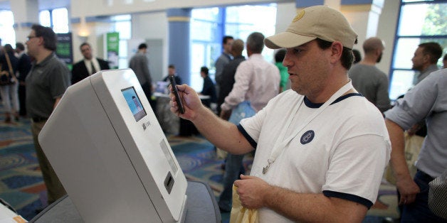MIAMI BEACH, FL - JANUARY 25: Eric Cogen uses a Bitcoin ATM to add bitcoins to his account while attending the North America