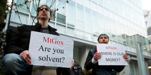 Kolin Burges, right, and another Mt. Gox customer hold placards while protesting outside a building housing the headquarters of Mt. Gox and its parent company Tibanne Co. in Tokyo, Japan, on Tuesday, Feb. 25, 2014. Mt. Gox, the Bitcoin exchange that halted withdrawals this month, went offline as industry peers distanced themselves from the Tokyo-based company in an effort to defend the virtual currency. Photographer: Kiyoshi Ota/Bloomberg via Getty Images
