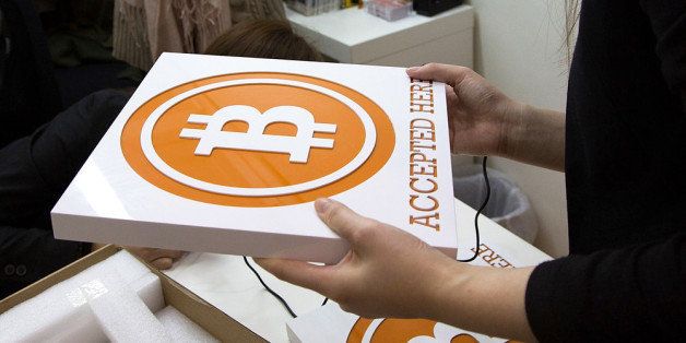 HONG KONG - FEBRUARY 28: A worker holds a sign at the first bitcoin retail store open in Hong Kong on February 28, 2014 in Hong Kong. Asia Nexgen, a Hong Kong based bitcoin exchange has launched a physical store enabling customers to purchase bitcoin and store it in their digital bitcoin wallets. Bitcoin Group HK and Hong Kong Bitcoin ATM plan to launch bitcoin 'ATM's machines in the area. in 2008 Bitcoin was launched as an alternative currency, with the commodity boasting the ability to be transferred without the need of the traditional monetary banking system. (Photo by Lam Yik Fei/Getty Images)