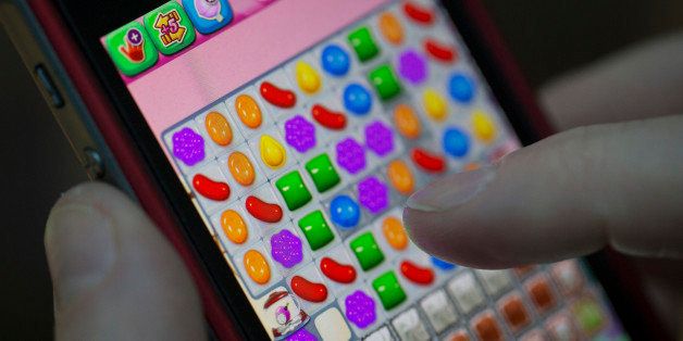 A user plays the 'Candy Crush Saga' puzzle game on an Apple.Inc iPhone 5 in this arranged photograph in London, U.K., on Tuesday, Feb. 18, 2014. King Digital Entertainment Plc, maker of the popular 'Candy Crush Saga' puzzle game on Facebook Inc. and Apple Inc. products, said it will raise $500 million in a U.S. share sale. Photographer: Simon Dawson/Bloomberg via Getty Images
