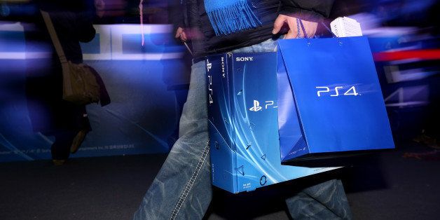 A customer carries a newly-purchased Sony Corp. PlayStation 4 (PS4) game console during the console's launch event in Seoul, South Korea, on Tuesday, Dec. 17, 2013. Sony is confident it can meet analysts' sales estimates of 3 million units by year-end and its own target of 5 million units by March, Jack Tretton, president and chief executive officer of the company's U.S. computer entertainment division, said Nov. 11. Photographer: SeongJoon Cho/Bloomberg via Getty Images