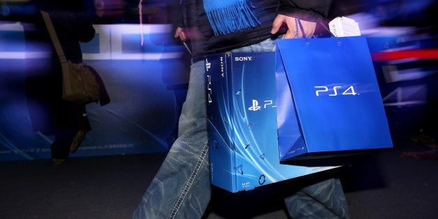 A customer carries a newly-purchased Sony Corp. PlayStation 4 (PS4) game console during the console's launch event in Seoul,