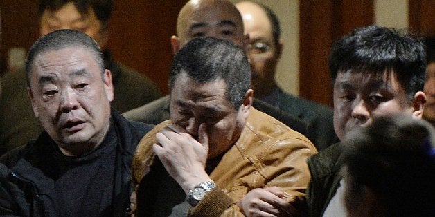 Grieving Chinese relatives of passengers on the missing Malaysia Airlines flight MH370 leave after being told of their deaths