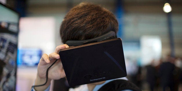 An attendee tries on the Oculus VR Inc. Rift virtual reality headset at the Boeing Co. booth during the Singapore Airshow hel