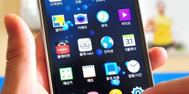 A South Korean customer looks at Samsung's Galaxy S5 smartphone at a mobile phone shop in Seoul on March 27, 2014. Samsung vo