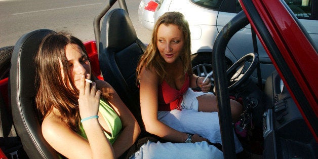 ROME - JUNE 10: Violante Pasolini, 17, (R) and Ludovica Lombardini, 17, (L) sit in Violante's small car as they go to the beach June 10, 2004 in Rome, Italy. In Rome privileged teenagers get around mainly in very expensive small cars for which they don't need a license plate or a driver's license. They all dress in the same metropolitan style, and spend most of their free time wandering around not doing much. Many teenagers' status symbols are cloths, mobile phone and accessories. Most of them have credit cards and act as if they are adults. (Photo by Marco Di Lauro/Getty Images)