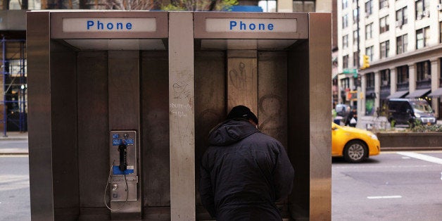 NEW YORK, NY - MAY 02: A man stands in a public phone booth on a Manhattan street on May 2, 2014 in New York City. New York Mayor Bill de Blasio has called for proposals to turn underused phone booths into Wi-Fi hot spots. If successful the program would create one of the largest free public wi-fi networks in the country. (Photo by Spencer Platt/Getty Images)