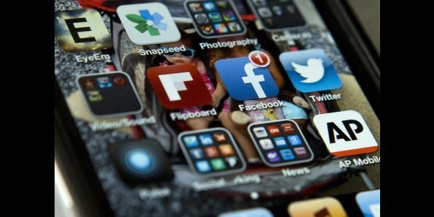 A view of an iPhone in Washington Tuesday, May 21, 2013, showing the Twitter and Facebook apps among others. A new poll finds that teens are sharing more about themselves on social media. They?re also moving increasingly to Twitter to avoid their parents and the "oversharing" that they see on Facebook. (AP Photo/Evan Vucci)