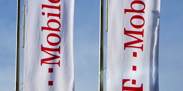 Flags branded with the logo for T-Mobile, operated by Deutsche Telekom AG, are seen flying outside the company's headquarters in Prague, Czech Republic, on Monday, Feb. 10, 2014. Deutsche Telekom AG agreed to acquire full ownership of its Czech unit, betting on a recovery in the eastern European telecommunications market that contribute to almost a quarter of the German carrier's revenue. Photographer: Martin Divisek/Bloomberg via Getty Images