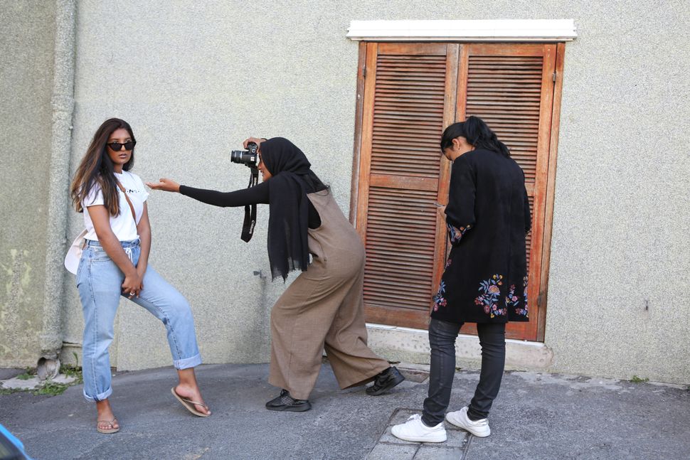 Young women taking photographs outside the Auwal Mosque in Bo-Kaap.
