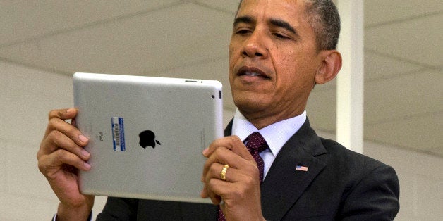 President Barack Obama looks at a classroom iPad in a seventh grade classroom before speaking about his ConnetED goal of connecting 99% of students to next generation broadband and wireless technology within five years, Tuesday, Feb. 4, 2014, at Buck Lodge Middle School in Adelphi, Md. (AP Photo/Jacquelyn Martin)