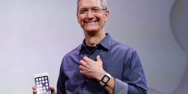 Apple CEO Tim Cook, holding an IPhone 6 Plus, discusses the new Apple Watch and iPhone 6s on Tuesday, Sept. 9, 2014, in Cupertino, Calif. (AP Photo/Marcio Jose Sanchez)