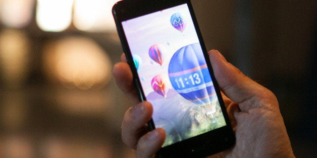 A man holds the new Fire smartphone by Amazon.com Inc. during a demonstration at a news conference in Berlin, Germany, on Monday, Sept. 8, 2014. Amazon.com Inc., the worlds largest online retailer, will start selling its Fire phone in Germany and the U.K. in an effort to win a bigger slice of the smartphone market and sell more services in Europe. Photographer: Krisztian Bocsi/Bloomberg via Getty Images