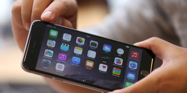 TOKYO, JAPAN - SEPTEMBER 19: A customer looks at the new Iphone 6 Plus at the launch of the new Apple iPhone 6 and iPhone 6 plus at the Apple Omotesando store on September 19, 2014 in Tokyo, Japan. On September 19, Apple's new products, iPhone 6 and iPhone 6 Plus, with iOS 8 featuring 4.7-inch and 5.5-inch displays, have become available in the US, Australia, Canada, France, Germany, Hong Kong, Japan, Puerto Rico, Singapore and the UK, and will be available in more than 20 additional countries beginning on September 26. (Photo by Chris McGrath/Getty Images)