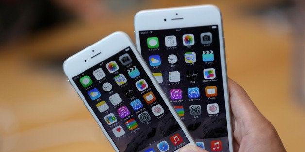 TOKYO, JAPAN - SEPTEMBER 19: A member of the press compares the new iPhone models at the launch of the new Apple iPhone 6 and iPhone 6 plus at the Apple Omotesando store on September 19, 2014 in Tokyo, Japan. On September 19, Apple's new products, iPhone 6 and iPhone 6 Plus, with iOS 8 featuring 4.7-inch and 5.5-inch displays, have become available in the US, Australia, Canada, France, Germany, Hong Kong, Japan, Puerto Rico, Singapore and the UK, and will be available in more than 20 additional countries beginning on September 26. (Photo by Chris McGrath/Getty Images)