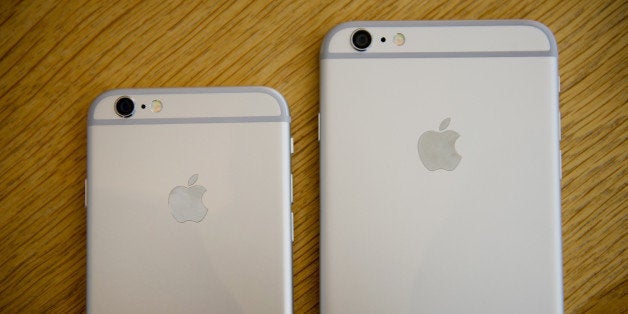 An Apple Inc. iPhone 6, left, and iPhone 6 Plus are arranged for a photograph during the sales launch at an Apple store in Palo Alto, California, U.S., on Friday, Sept. 19, 2014. Apple Inc.'s stores attracted long lines of shoppers for the debut of the latest iPhones, indicating healthy demand for the bigger-screen smartphones. The larger iPhone 6 Plus is already selling out at some stores across the U.S. Photographer: David Paul Morris/Bloomberg via Getty Images