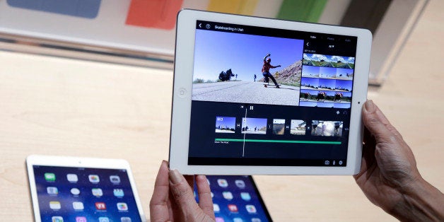 An Apple employee holds up the new iPad Air on Tuesday, Oct. 22, 2013, in San Francisco. Apple unveiled a new, thinner, lighter tablet called the "iPad Air" along with a slew of new Macs Tuesday at an event in San Francisco. The iPad Air weighs just 1 pound, compared with 1.4 pounds for the previous version. (AP Photo/Marcio Jose Sanchez)