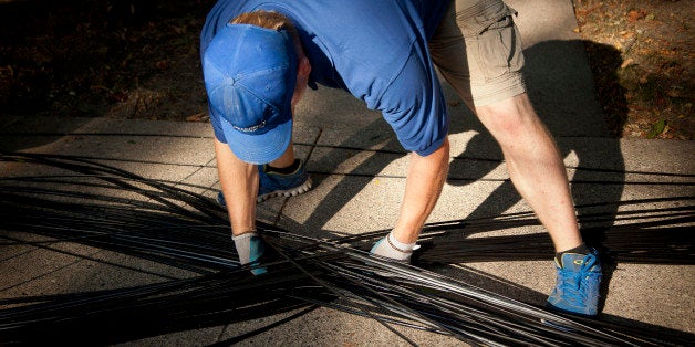 Richard Robert McKeever, a fiber install technician for US Internet Corp., adjusts fiber optic internet cable so it does not become tangled during installation in Minneapolis, Minnesota, U.S., on Thursday, Sept. 11, 2013. The US Internet Corp. gigabit residential service is symmetrical with Google Inc. Fiber offering upload speeds of 1 Gbps and 1,024 Mbps for downloads. Photographer: Ariana Lindquist/Bloomberg via Getty Images 