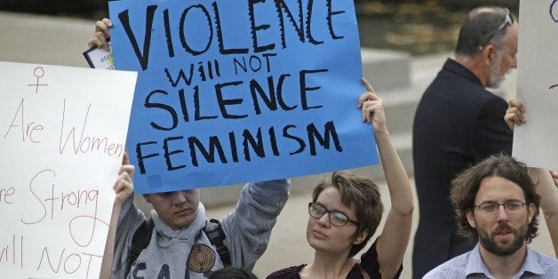 People protest on the campus of Utah State, Wednesday, Oct. 15, 2014, in Logan, Utah. Utah's campus gun laws are in the spotlight after a feminist speaker canceled a speech at Utah State University once she learned the school would allow concealed firearms despite an anonymous threat against her. School officials in Logan were set to go ahead with the event with extra police after consulting with federal and state law enforcement who told them the threat was consistent with ones Anita Sarkeesian receives when she gives speeches elsewhere. (AP Photo/Rick Bowmer)