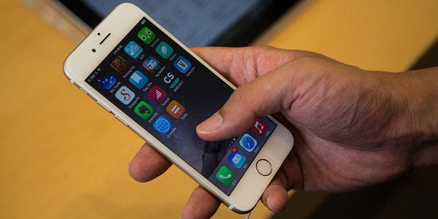 HONG KONG - SEPTEMBER 19: Customer looks at the new iPhones on display at the launch of the new Apple iPhone 6 and iphone 6 plus at the Apple IFC store on September 19, 2014 in Hong Kong, China. On September 19, Apple's new products, iPhone 6 and iPhone 6 Plus, with iOS 8 featuring 4.7-inch and 5.5-inch displays, have become available in the US, Australia, Canada, France, Germany, Hong Kong, Japan, Puerto Rico, Singapore and the UK, and will be available in more than 20 additional countries beginning on September 26.(Photo by Lam Yik Fei/Getty Images)