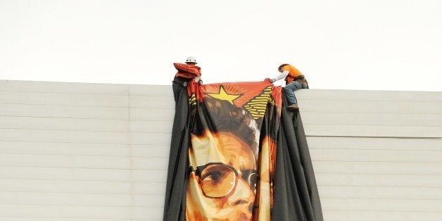 Workers remove a poster- banner for 'The Interview' from a billboard in Hollywood, California, December 18, 2014 a day after Sony announced it had no choice but to cancel the movie's Christmas release and pull it from theaters due to a credible threat. Sony defended itself Thursday against a flood of criticism for canceling the movie which angered North Korea and triggered a massive cyber-attack, as the crisis took a wider diplomatic turn. AFP PHOTO / MICHAEL THURSTON (Photo credit should read Michael THURSTON/AFP/Getty Images)