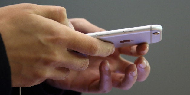 A customer tries out an Apple Inc. iPhone 6 at an Apple store in the China Central Mall in Beijing, China, on Tuesday, Nov. 11, 2014. Apple, which ended the fiscal fourth quarter with $155.2 billion in cash, is forecasting a record holiday sales quarter after introducing new bigger-screen iPhones and slimmer iPads. Photographer: Tomohiro Ohsumi/Bloomberg via Getty Images