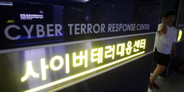FILE - In this July 16, 2013 file photo, a woman walks by a sign at Cyber Terror Response Center of National Police Agency in