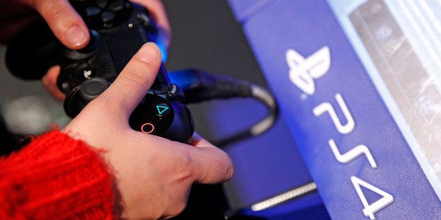 PARIS, FRANCE - DECEMBER 23: A visitor plays on Sony Playstation 4 video game console (PS4), produced by Sony Corp during the 'Noel de Geek' at the Cite des Sciences et de l'industrie on December 23, 2014 in Paris, France. 'Noel de Geek' takes place from December 23, 2014 till January 04, 2015. (Photo by Chesnot/Getty Images)