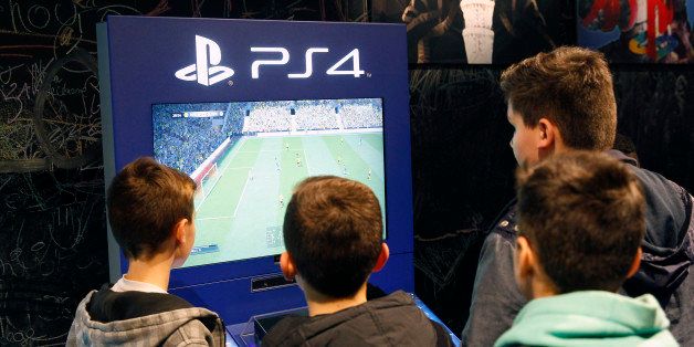 PARIS, FRANCE - DECEMBER 23: Visitors play at the 'FIFA 15' soccer game on Sony Playstation 4 video game console (PS4), produced by Sony Corp during the 'Noel de Geek' at the Cite des Sciences et de l'industrie on December 23, 2014 in Paris, France. 'Noel de Geek' takes place from December 23, 2014 till January 04, 2015. (Photo by Chesnot/Getty Images)
