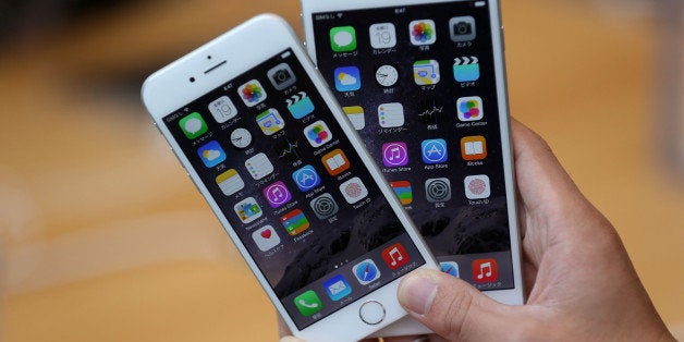 TOKYO, JAPAN - SEPTEMBER 19: A member of the press compares the new iPhone models at the launch of the new Apple iPhone 6 and iPhone 6 plus at the Apple Omotesando store on September 19, 2014 in Tokyo, Japan. On September 19, Apple's new products, iPhone 6 and iPhone 6 Plus, with iOS 8 featuring 4.7-inch and 5.5-inch displays, have become available in the US, Australia, Canada, France, Germany, Hong Kong, Japan, Puerto Rico, Singapore and the UK, and will be available in more than 20 additional countries beginning on September 26. (Photo by Chris McGrath/Getty Images)