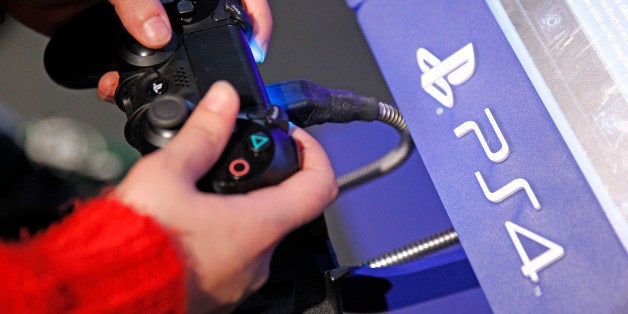 PARIS, FRANCE - DECEMBER 23: A visitor plays on Sony Playstation 4 video game console (PS4), produced by Sony Corp during the 'Noel de Geek' at the Cite des Sciences et de l'industrie on December 23, 2014 in Paris, France. 'Noel de Geek' takes place from December 23, 2014 till January 04, 2015. (Photo by Chesnot/Getty Images)