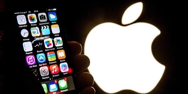 An illustration of an iPhone held up in front of the Apple Inc. logo taken of January 30, 2015 in Lille. AFP PHOTO / PHILIPPE HUGUEN (Photo credit should read PHILIPPE HUGUEN/AFP/Getty Images)