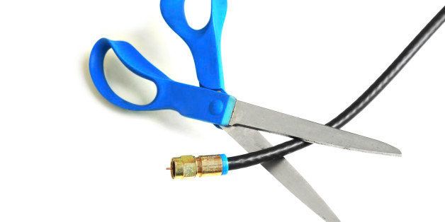 Scissors cutting through a coaxial cable - cut the cable tv concept