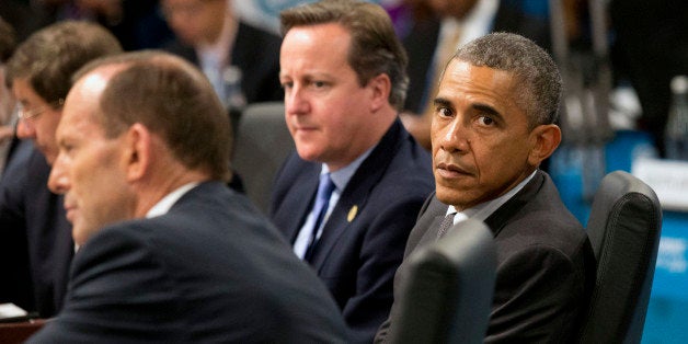 U.S. President Barack Obama, right, looks away as Prime Minister of Australia Tony Abbott, left, address a plenary session while British Prime Minister David Cameron looks on during the G-20 summit in Brisbane, Australia, Saturday, Nov. 15, 2014. (AP Photo/Rob Griffith,Pool)