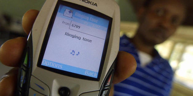 Nairobi, KENYA: A client receives a customized ring tone on her phone, 21, October 2006 in Nairobi. Amid an African explosion in mobile technology, personal ringtones are amongst a growing range of services that parallel mobile telephone service providers are offering the Kenyan market. From agricultural product prices to stock exchange intel and dating services, entrepreneur of local firm, Cellulant, Ken Njoroge is one of a growing number of innovative young entrepreneurs delivering entertainment, information and even romance to cell phone users, whose numbers have skyrocketed from 15,000 in 1999 to 5.6 million at the end of last year. AFP PHOTO/TONY KARUMBA (Photo credit should read TONY KARUMBA/AFP/Getty Images)