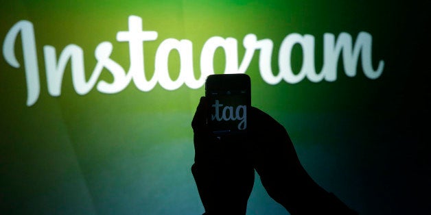 A journalist makes a video of the Instagram logo using the new video feature at Facebook headquarters in Menlo Park, Calif., Thursday, June 20, 2013. (AP Photo/Marcio Jose Sanchez)