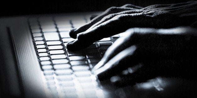 Concept photo in high contrast black and white of hacker's fingers on keyboard