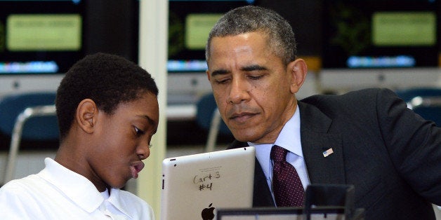 A student shows US President Barack Obama how he is working to creat an ebook with an iPad in a classroom at Buck Lodge Middl