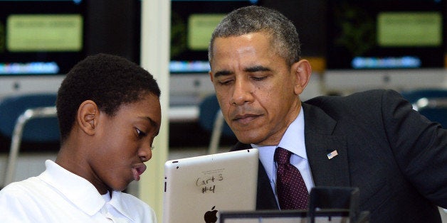 A student shows US President Barack Obama how he is working to creat an ebook with an iPad in a classroom at Buck Lodge Middle School in Adelphi, Maryland, on February 4, 2014 before speaking detailing progress toward his ConnectED goal of connecting 99 percent of students to next-generation broadband and wireless technology within five years. AFP PHOTO/Jewel Samad (Photo credit should read JEWEL SAMAD/AFP/Getty Images)