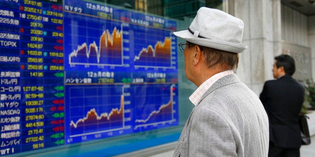 People look at an electronic stock indicator of a securities firm in Tokyo Thursday, April 23, 2015. Asian shares rose Thursday despite fresh data showing economic weakness in China and Japan, as investors pinned their hopes on further stimulus measures. Monetary easing and ample liquidity are drawing foreign investors, boosting markets across the region. Japan's benchmark Nikkei 225 remained above the 20,000 mark it broached for the first time in 15 years the day before, gaining 0.27 percent to 20,187.65. (AP Photo/Shizuo Kambayashi)