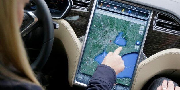 In this Tuesday, April 7, 2015 photo, Alexis Georgeson of Tesla Motors shows off the navigation screen during test drive of the new Tesla Model S 70-D electric car in Detroit. Tesla is going after mainstream luxury car buyers by boosting the range, power and price of its low-end Model S. The $75,000 all-wheel-drive 70-D can go a government-certified 240 miles per charge, has 514 horsepower and can go from zero to 60 in 5.2 seconds. (AP Photo/Carlos Osorio)