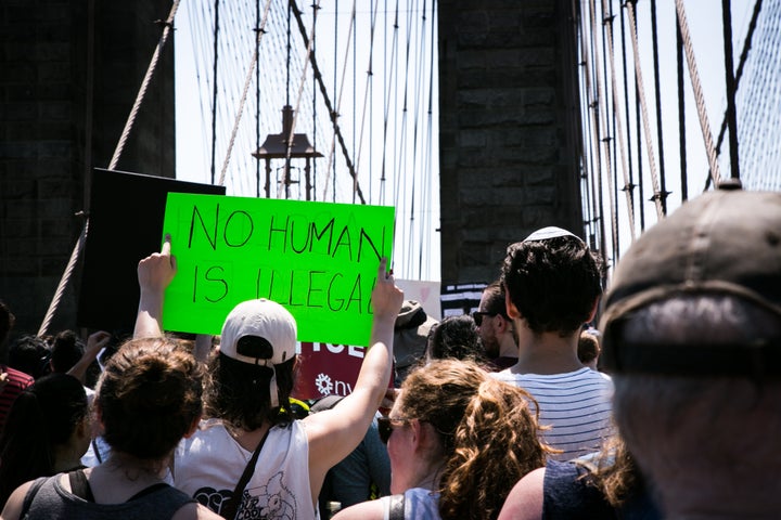 A demonstrator holds a sign reading "No Human Is Illegal" during a protest against President Trump's immigration policies in New York, New York on June 30, 2018.